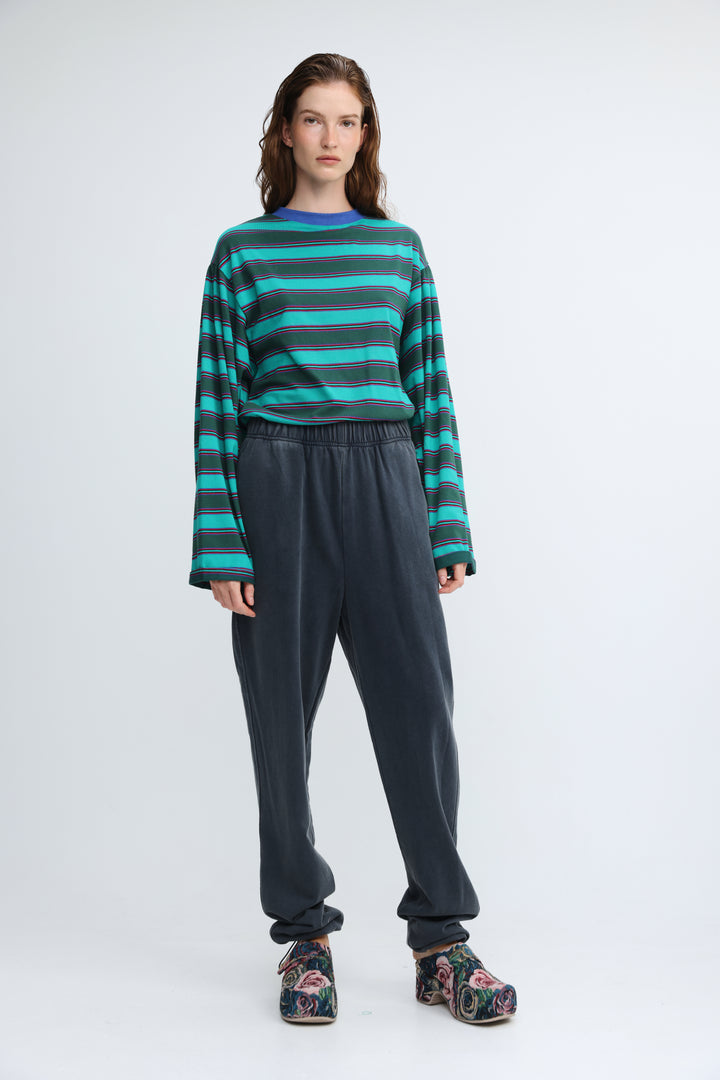 Zone dark blue joggers shown front view with loose fit and paired with long-sleeved teal and dark green striped top