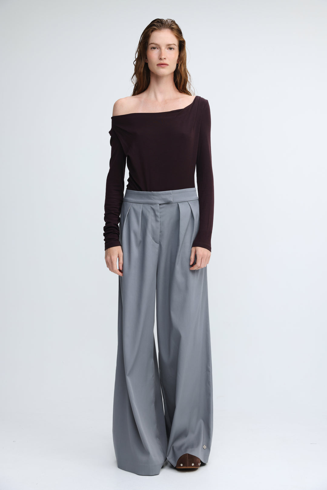 Miss purple shirt featuring a pair of high waist wide-leg gray trousers with a pleated front shown from the front view