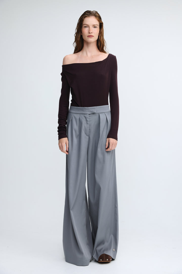 Miss purple shirt featuring a pair of high waist wide-leg gray trousers with a pleated front shown from the front view