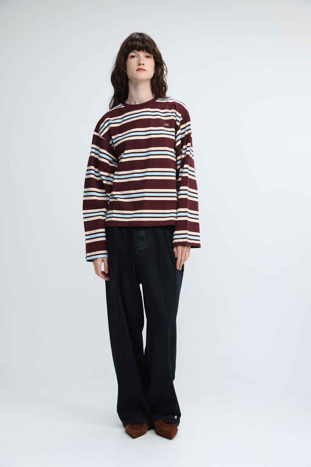 Front view of a maroon and white striped long-sleeved sweater with a small embroidered patch on the chest