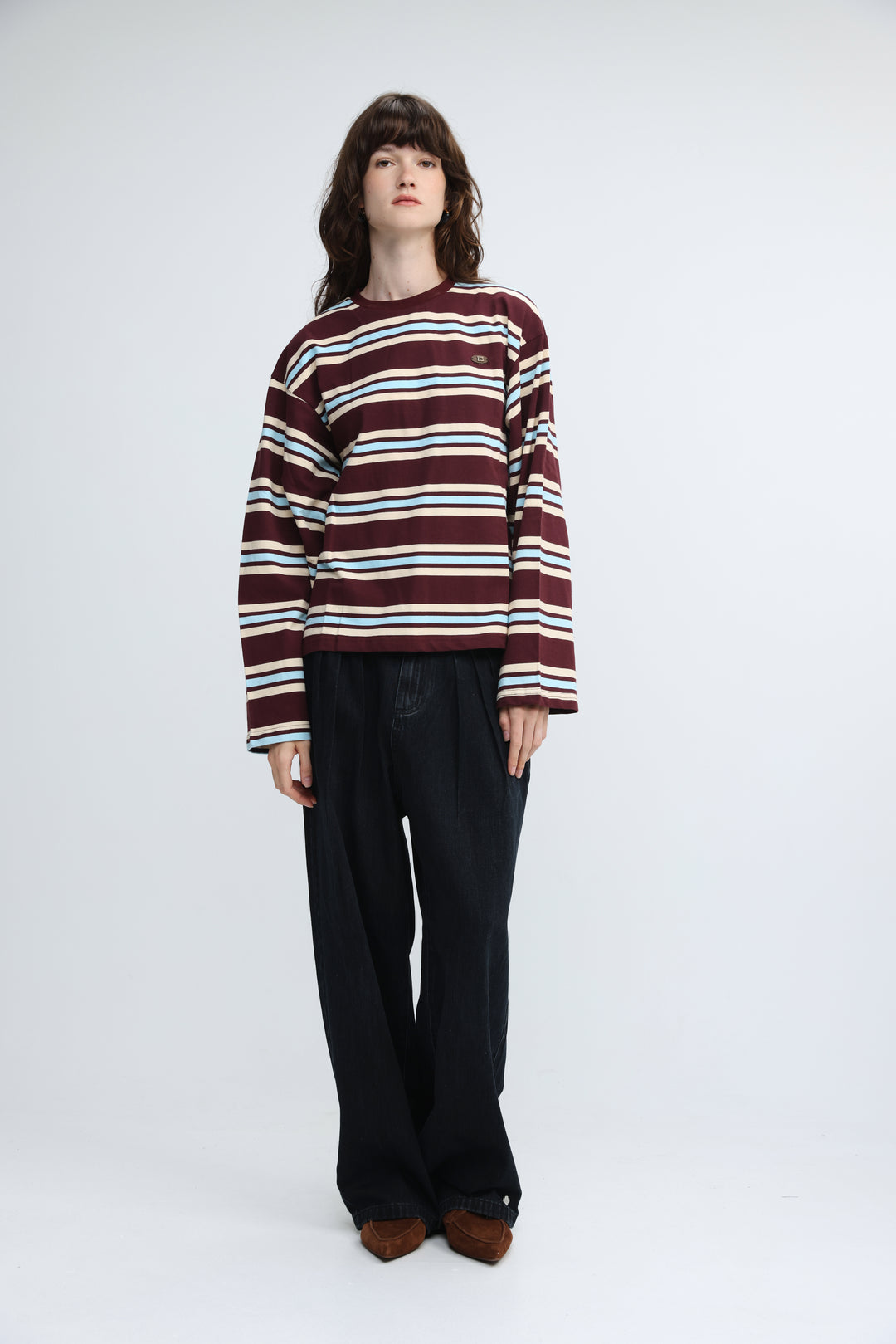 Front view of a maroon and white striped long-sleeved sweater with a small embroidered patch on the chest