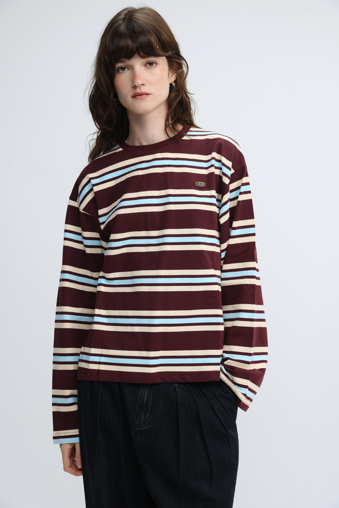 Maroon wine striped long-sleeve crewneck sweater with light blue and cream stripes and small embroidered logo on left chest