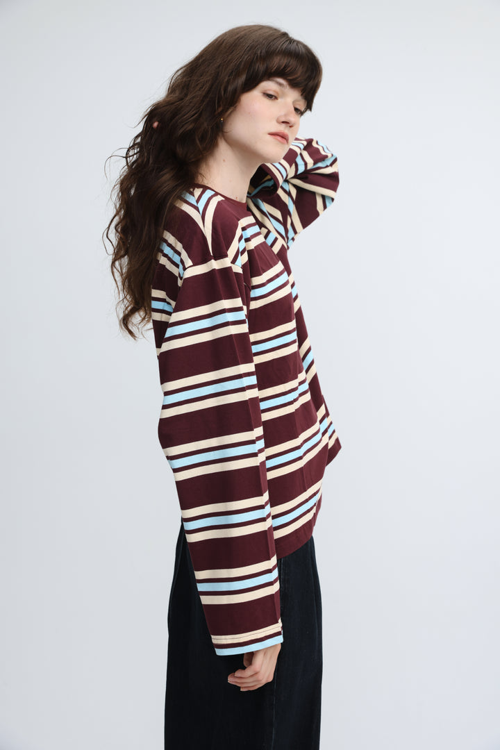 A maroon, light blue, and cream striped long-sleeved shirt with a relaxed fit shown from the front