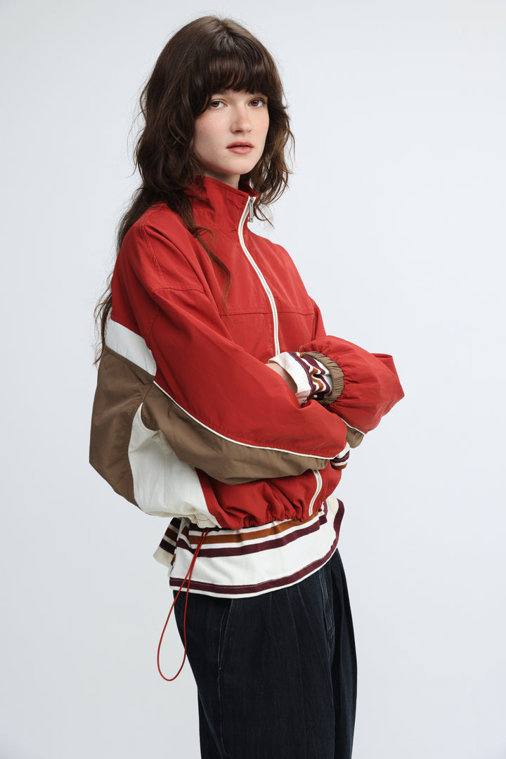 Madas red varsity-style jacket with beige panels, white trim, front view, ribbed cuffs, and drawstring waistband