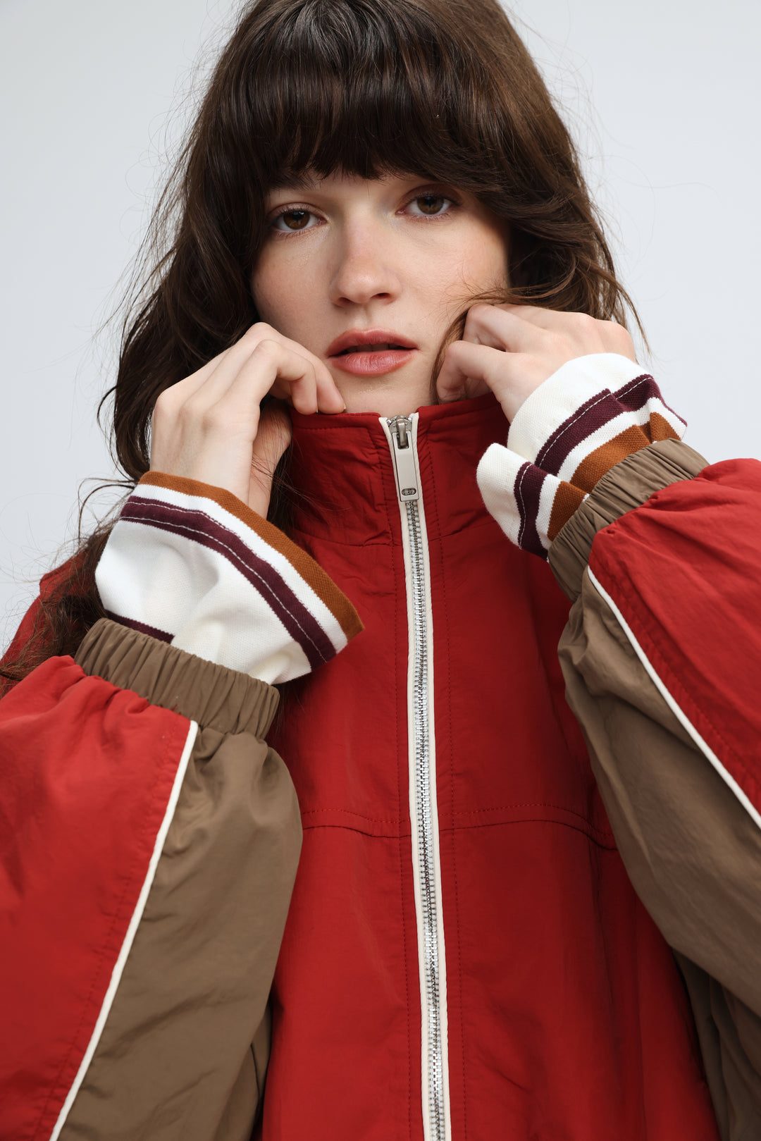 Madas red varsity jacket with brown sleeves and white maroon and tan striped cuffs shown from the front