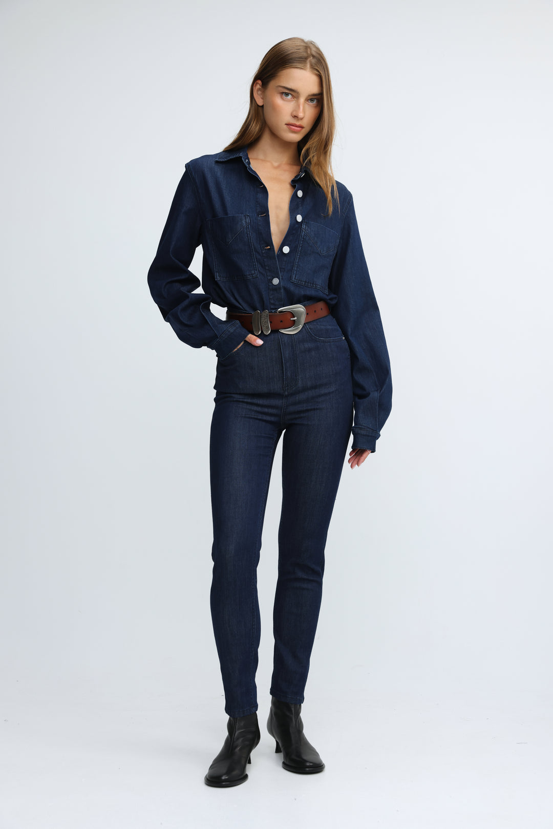 A navy blue denim shirt with long sleeves and button-down front paired with matching high-waisted jeans front view