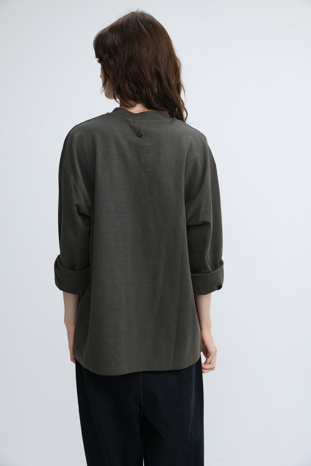 Olive green loose-fitting long-sleeved shirt with rolled cuffs and small button at neckline front view