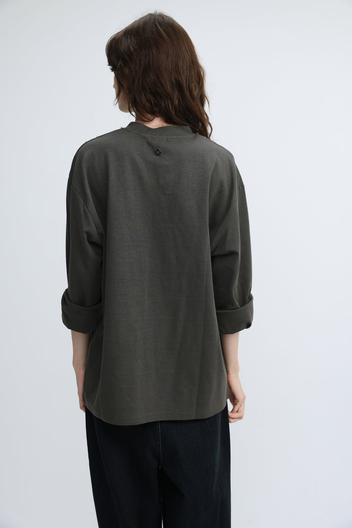 Olive green loose-fitting long-sleeved shirt with rolled cuffs and small button at neckline front view