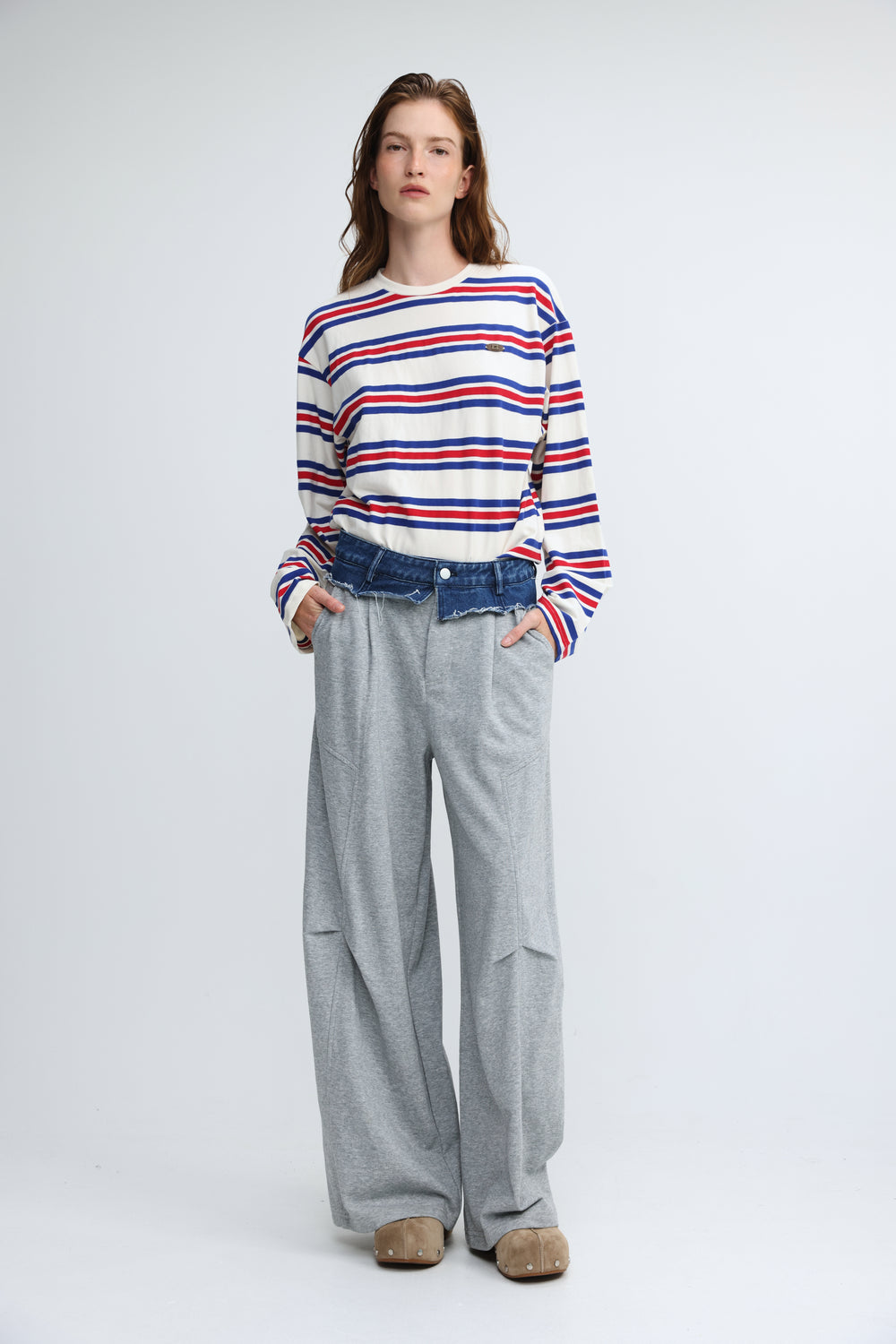 A woman wearing a front view red, white, and blue striped long-sleeved federer blue striped shirt with a chest logo