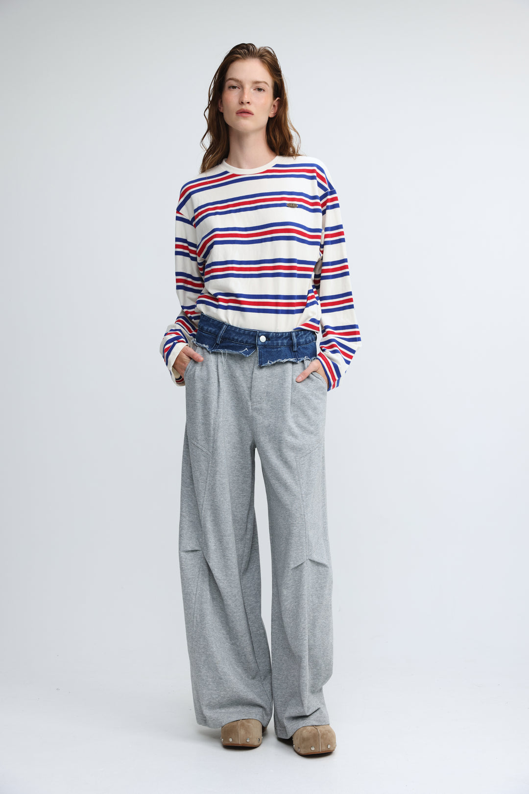 A woman wearing a front view red, white, and blue striped long-sleeved federer blue striped shirt with a chest logo