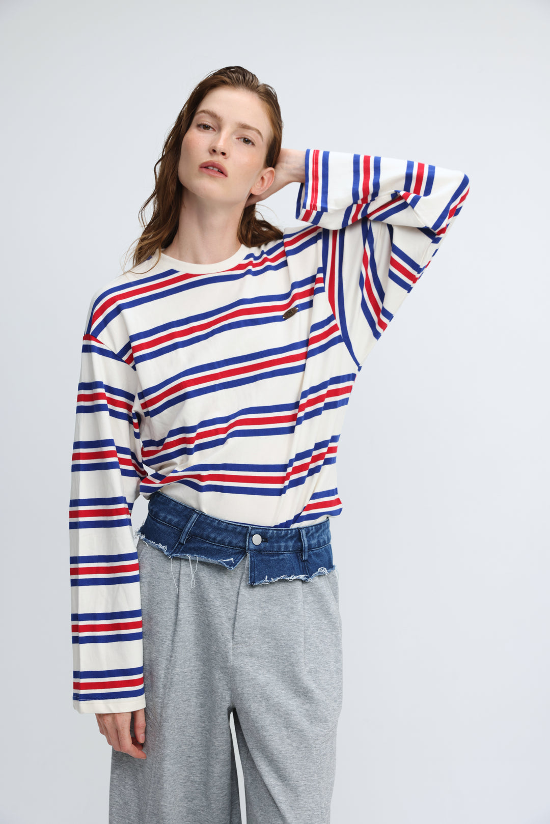 Long-sleeved crew-neck sweater with bold horizontal red, blue, and white stripes shown from the front