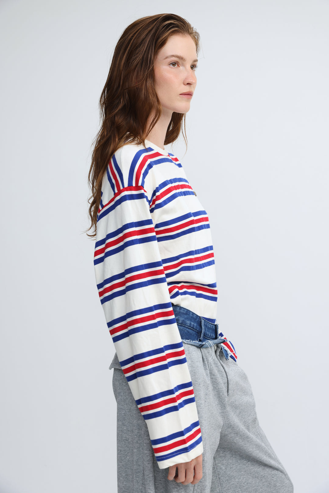 A woman wearing a front view of a red white and blue federer blue striped long-sleeved crew-neck sweater