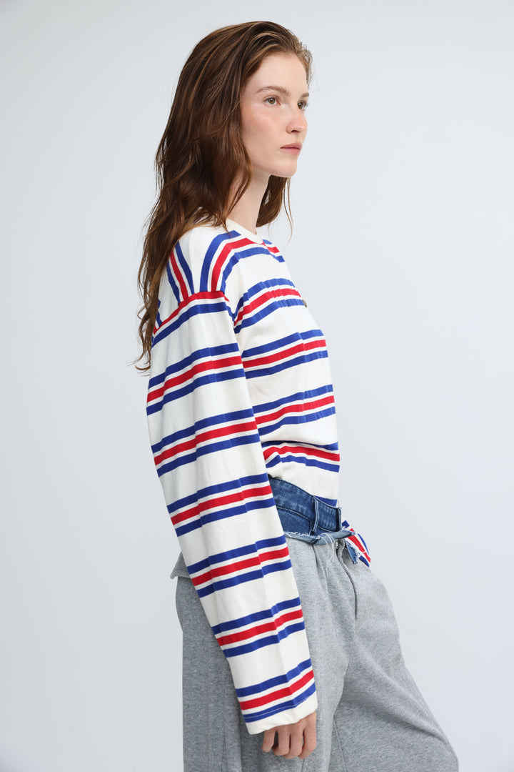 A woman wearing a front view of a red white and blue federer blue striped long-sleeved crew-neck sweater