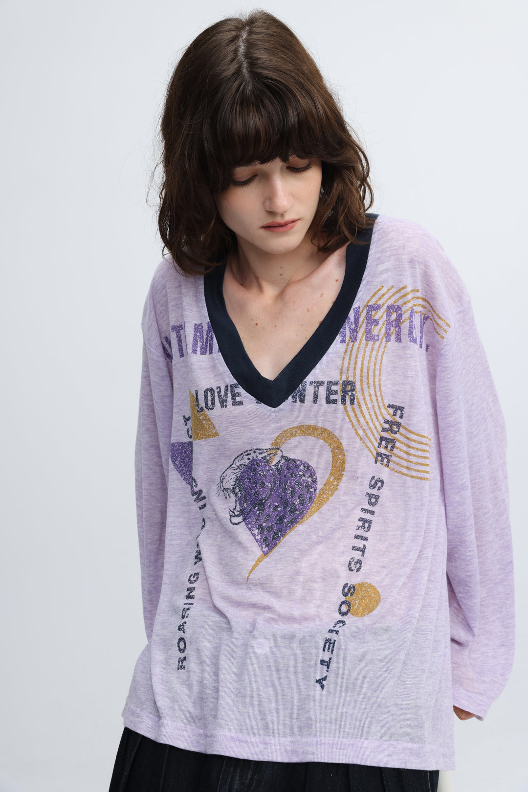 Lavender long-sleeved v-neck tee with black trim and glittery purple and gold graphic prints on front