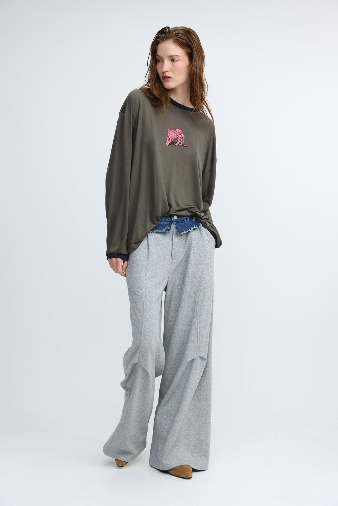 Olive green oversized long-sleeve top with pink embroidered bear on chest shown from the front