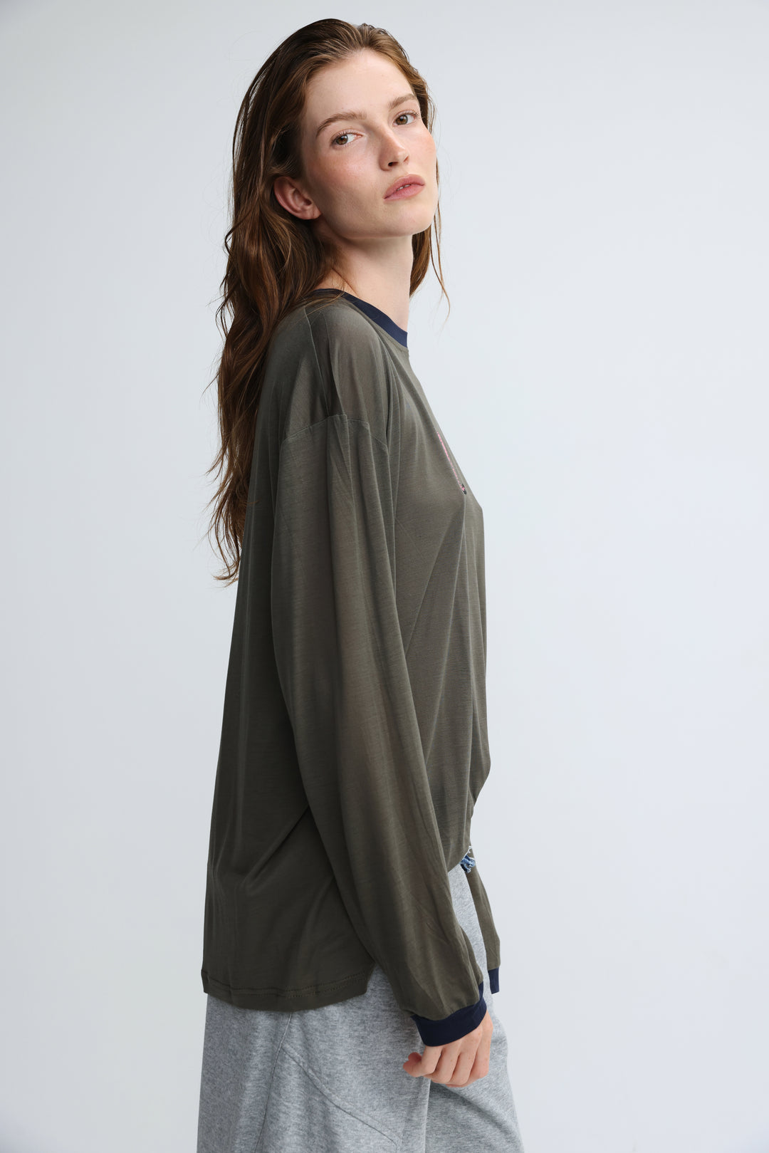 Pink tiger grey shirt front view with olive green long-sleeved blouse featuring navy blue ribbed collar and cuffs
