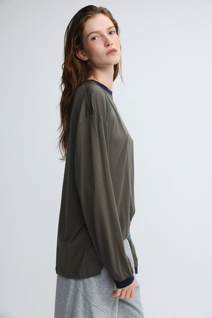 Pink tiger grey shirt front view with olive green long-sleeved blouse featuring navy blue ribbed collar and cuffs