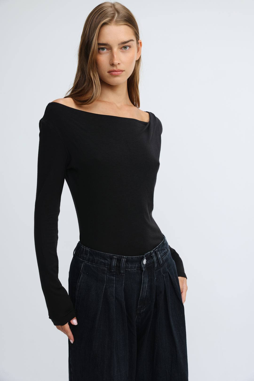 Black off-the-shoulder long-sleeve top with fitted silhouette and ribbed texture shown from the front