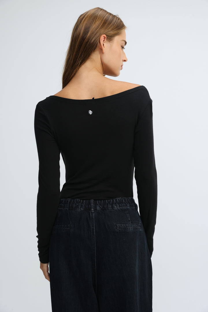 Black off the shoulder long sleeve top with small silver logo at the neckline front view Miss Black Shirt