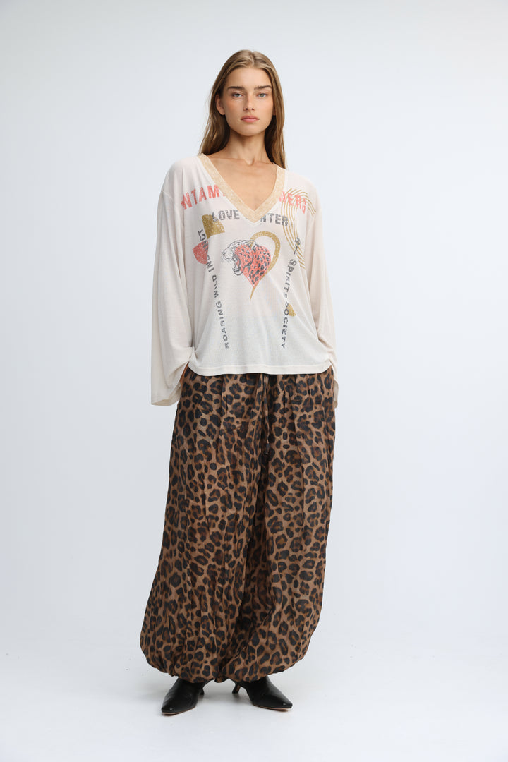 A flowing off-white long-sleeved jungle cream v shirt with a v-neck and pink and gold graphic prints on the front