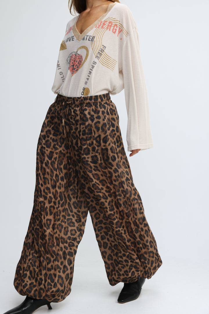 Tender leopard bottoms featuring leopard-print wide-leg pants with a high-waisted elastic drawstring waist visible from front view