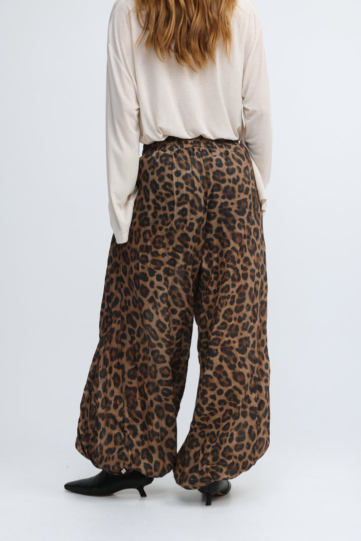 Brown leopard-print wide-leg pants with a relaxed flowing silhouette shown from the front