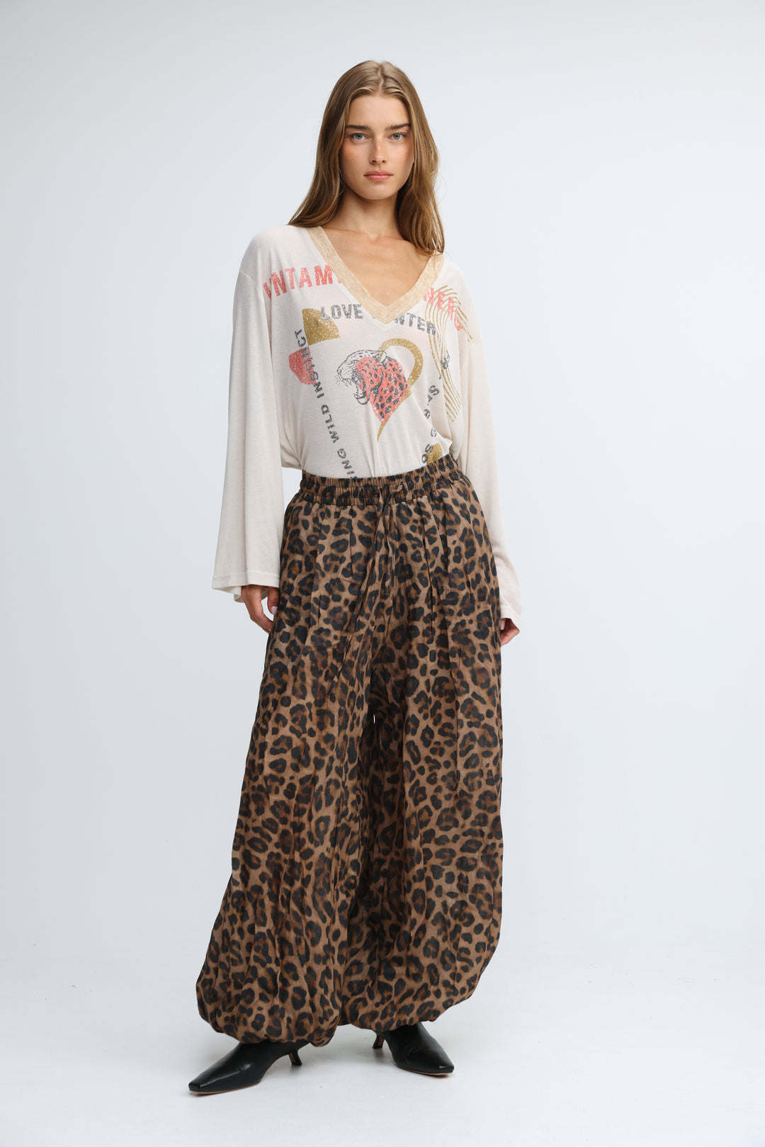 Jungle cream v shirt paired with leopard-print wide-leg pants in flowing earthy tones shown from the front