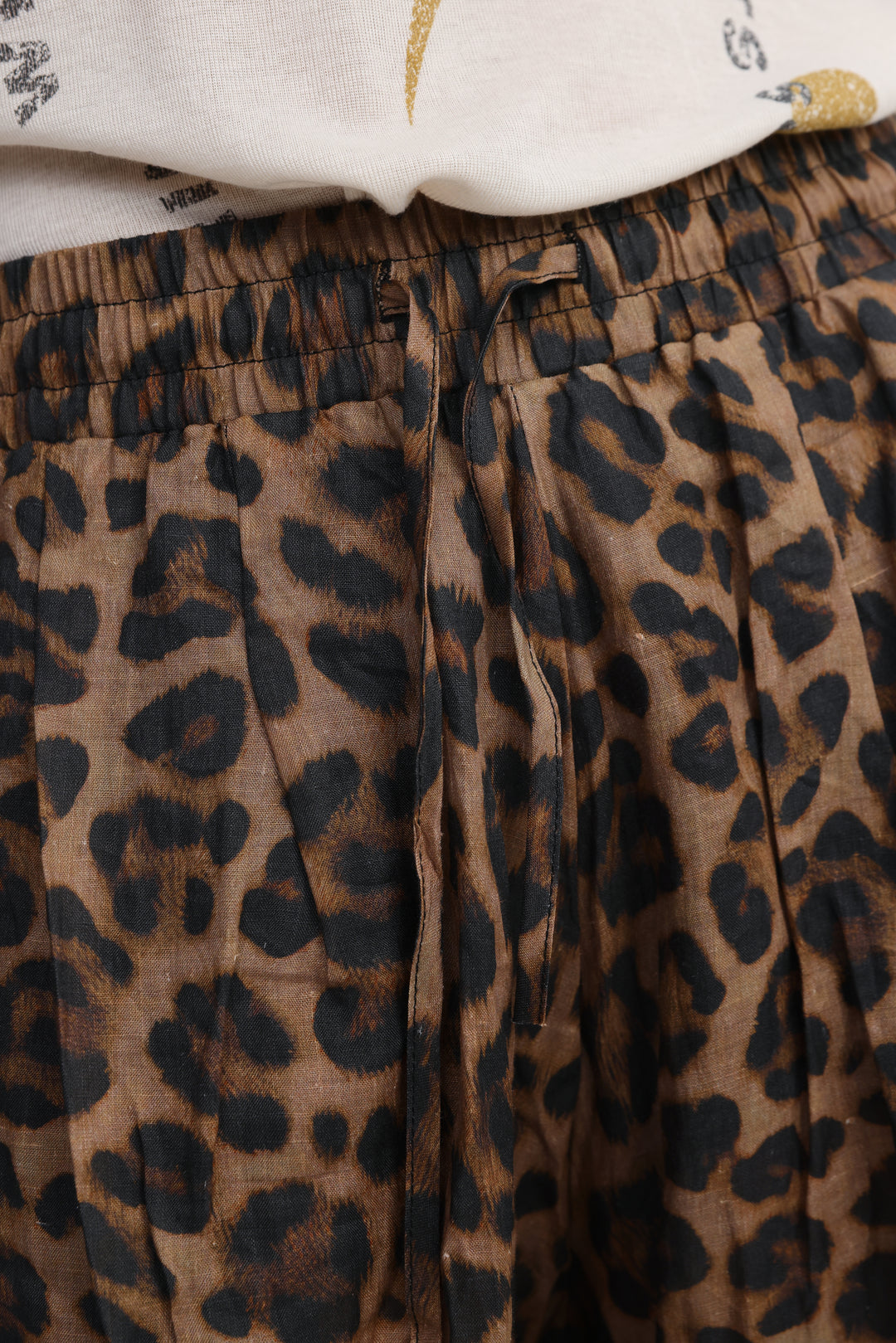 Brown and black leopard-print pleated pants with elastic waistband shown from the front