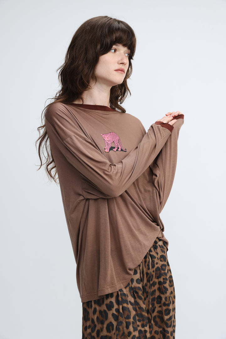 A brown long-sleeved shirt with a dark brown ribbed neckline and cuffs and an embroidered pink leopard on the chest