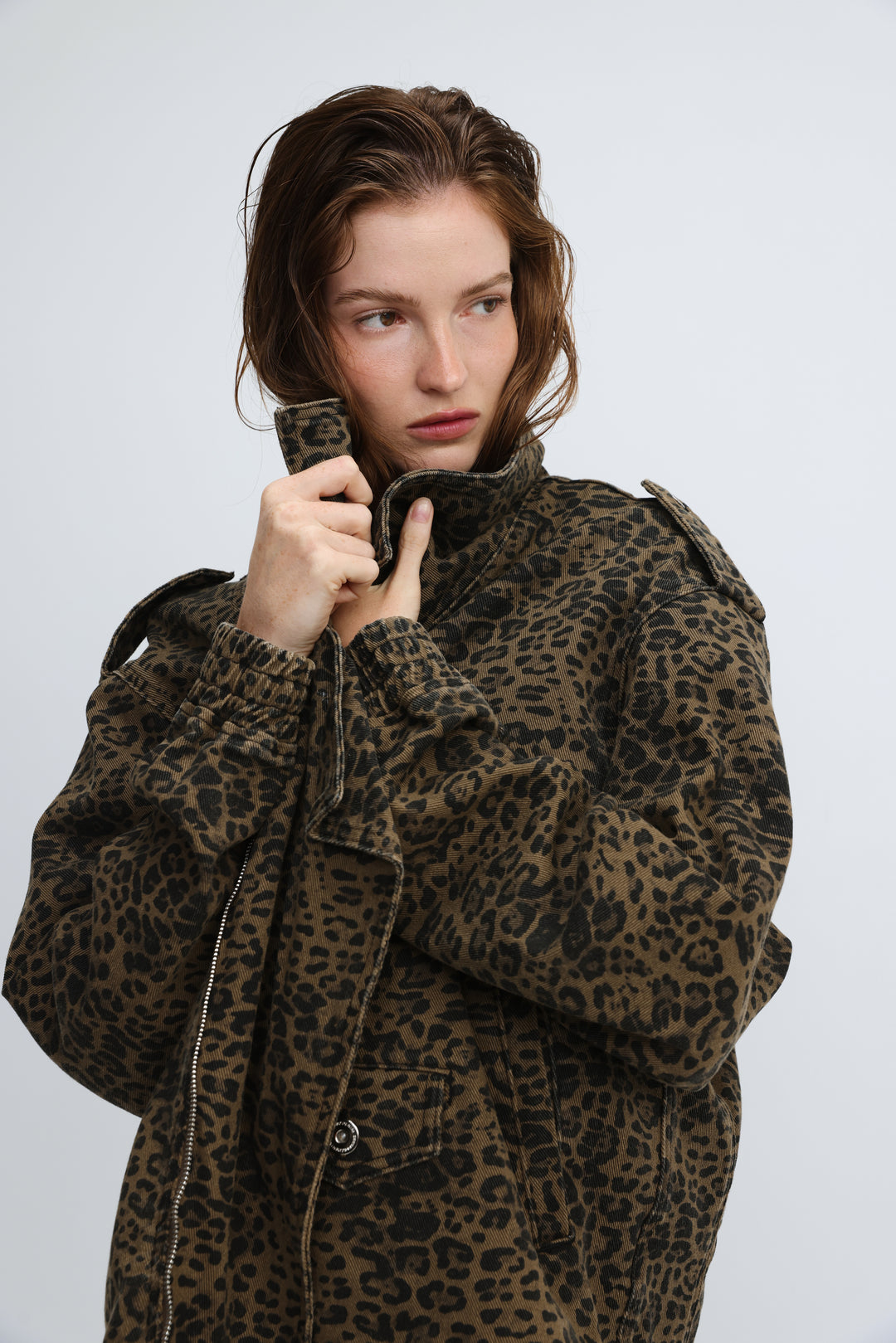 A woman wearing a brown and black cheers leopard jacket with adjustable cuffs shoulder epaulets and front pockets