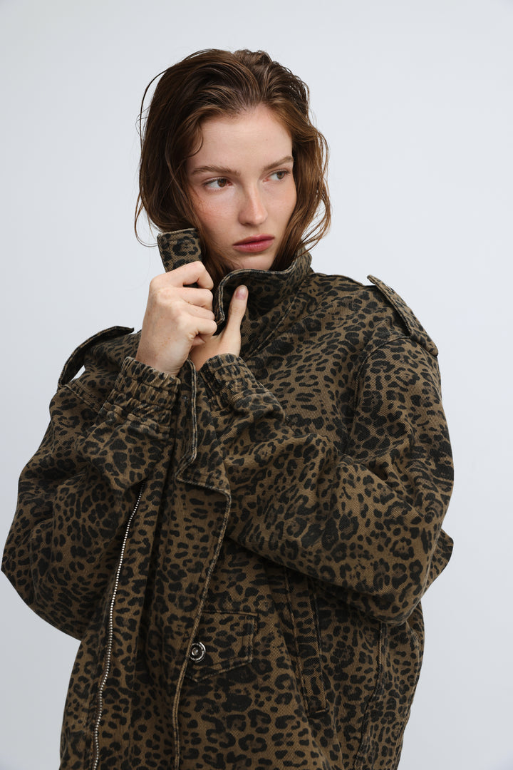 A woman wearing a brown and black cheers leopard jacket with adjustable cuffs shoulder epaulets and front pockets