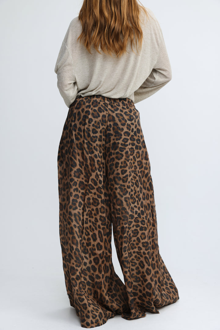 Tender leopard wide bottoms featuring wide-leg flowy pants in leopard print shown from the front