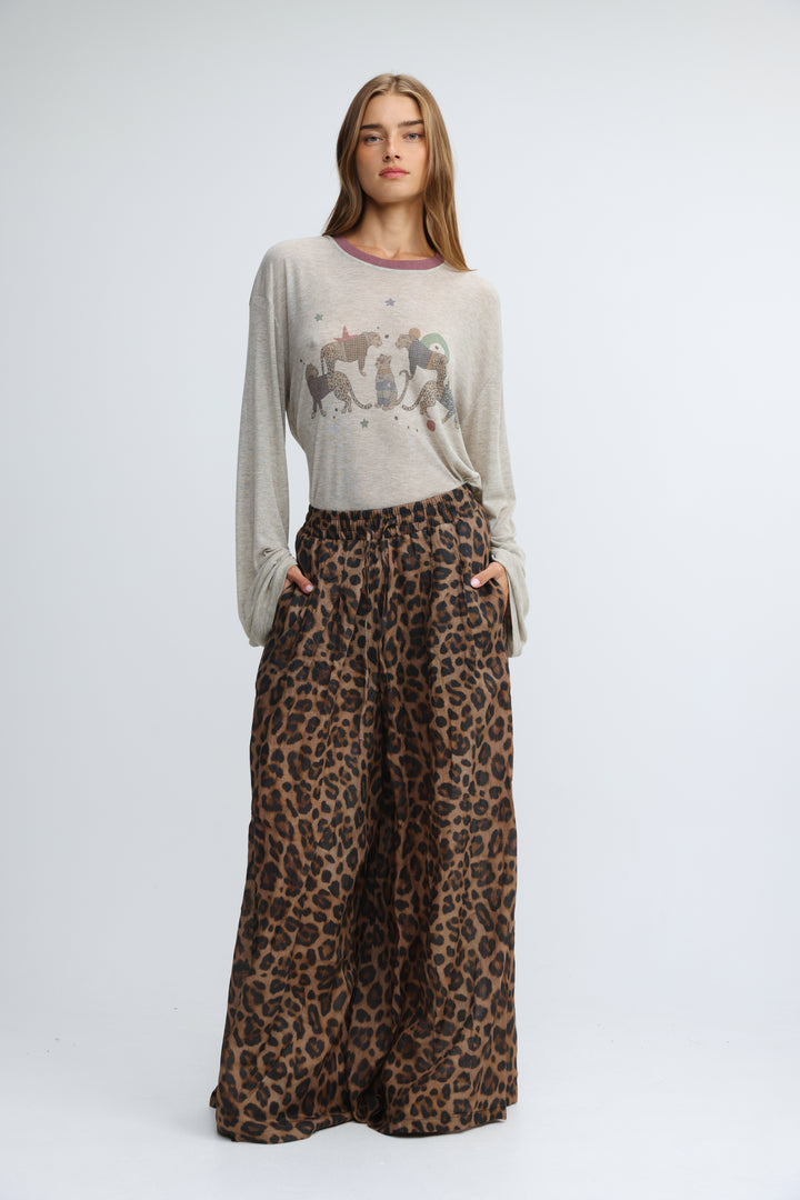 A woman wearing a jungle grey long-sleeved shirt with purple trim and an animal print graphic on the front