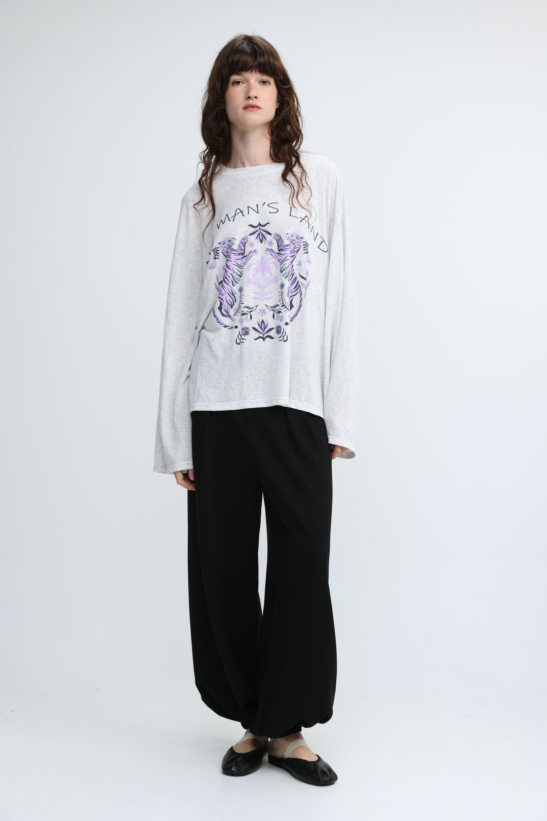 White long-sleeved graphic tee with purple and black tiger emblem and mans land text on chest front view