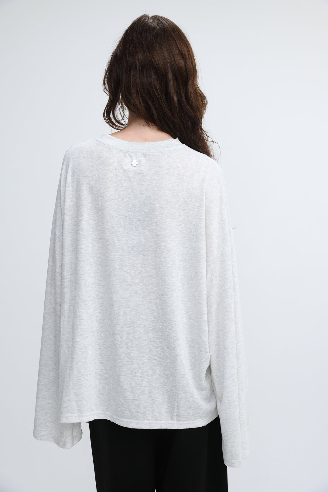 NML grey shirt is a soft light gray long-sleeved top with a relaxed fit and subtle texture shown from the front