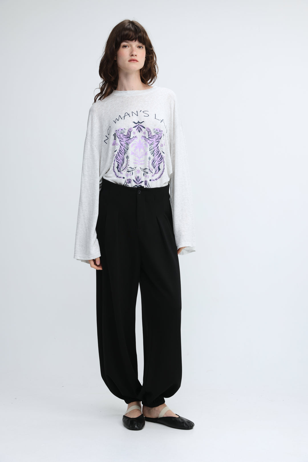 White long-sleeved top with purple graphic print and relaxed fit shown from the front in everything black bottoms product