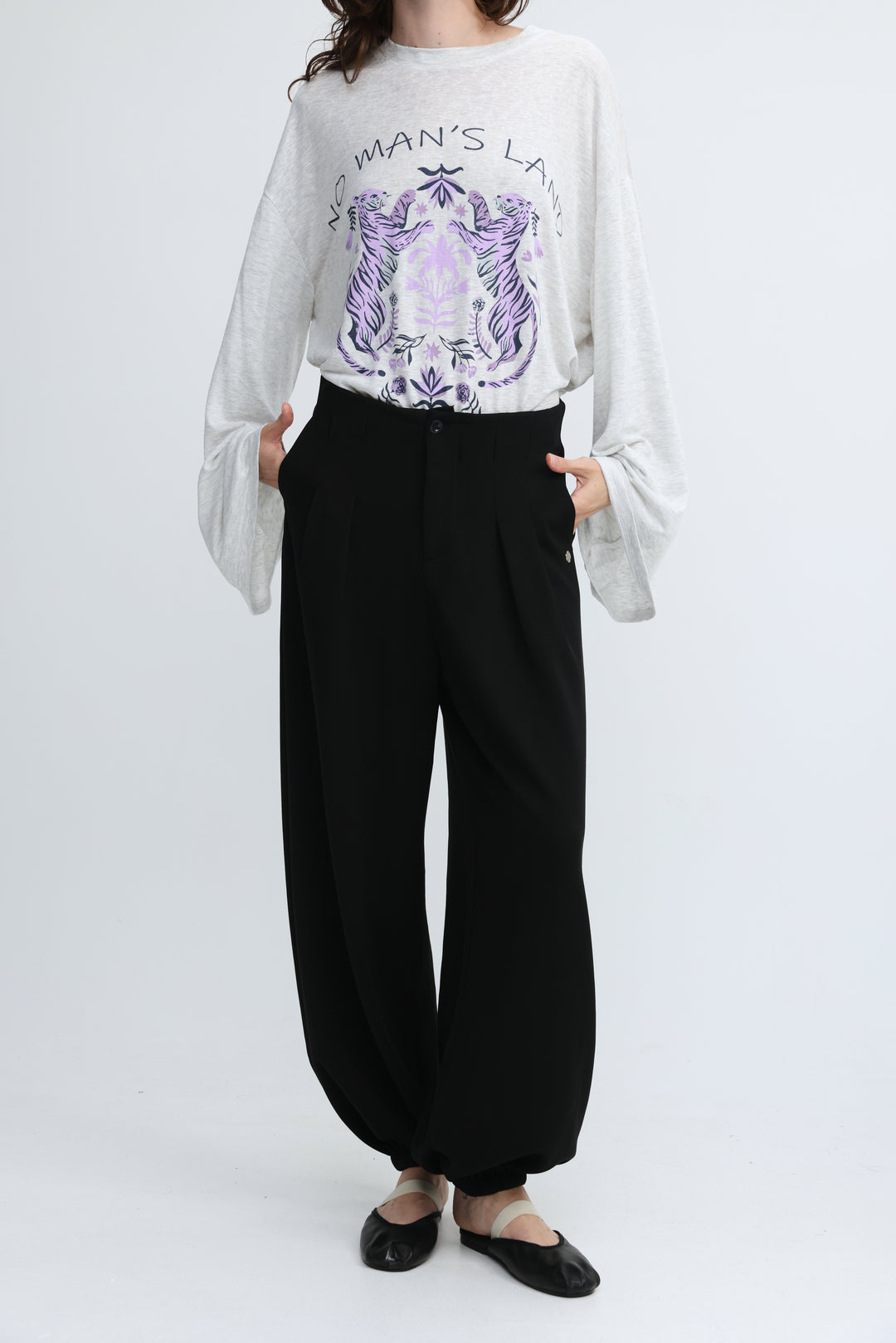 White long-sleeved top with purple tiger graphic and no mans land text paired with everything black bottoms front view