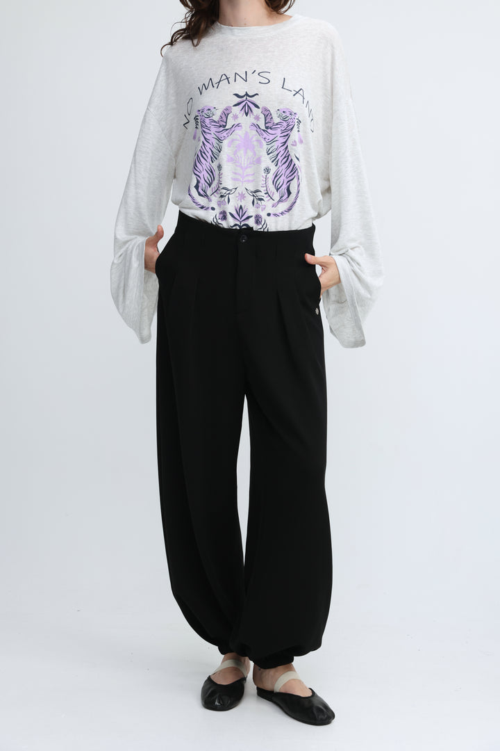 White long-sleeved top with purple tiger graphic and no mans land text paired with everything black bottoms front view