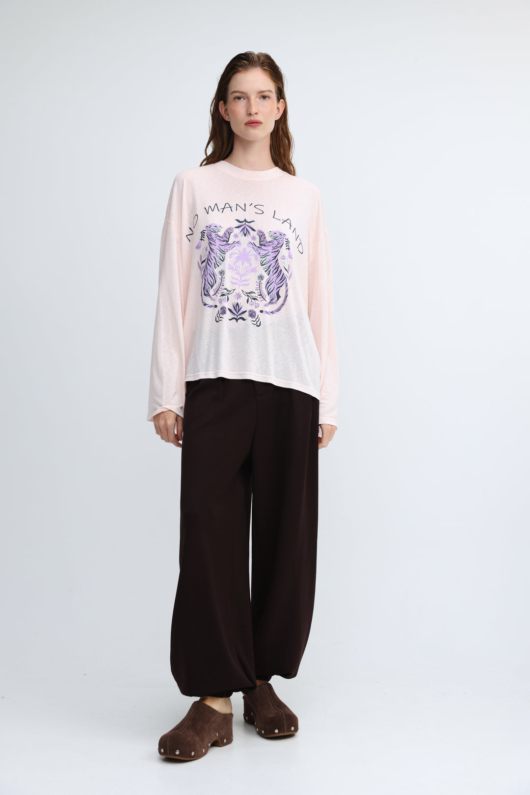 Nml pink shirt soft pink long-sleeved tee with a purple and white crest graphic and no mans land text on front