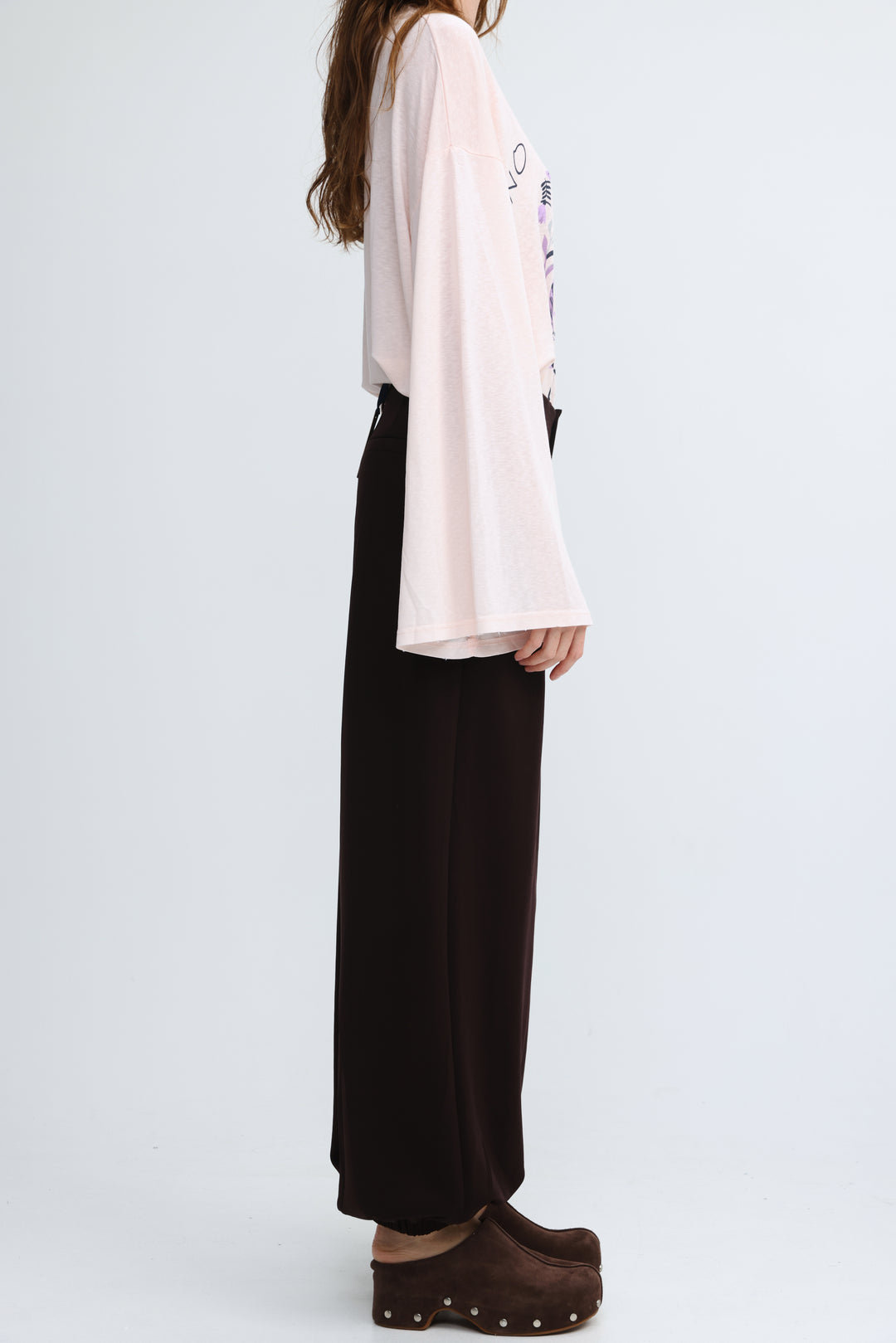A soft blush pink long-sleeved top with relaxed fit and subtle graphic print on the back from everything brown bottoms