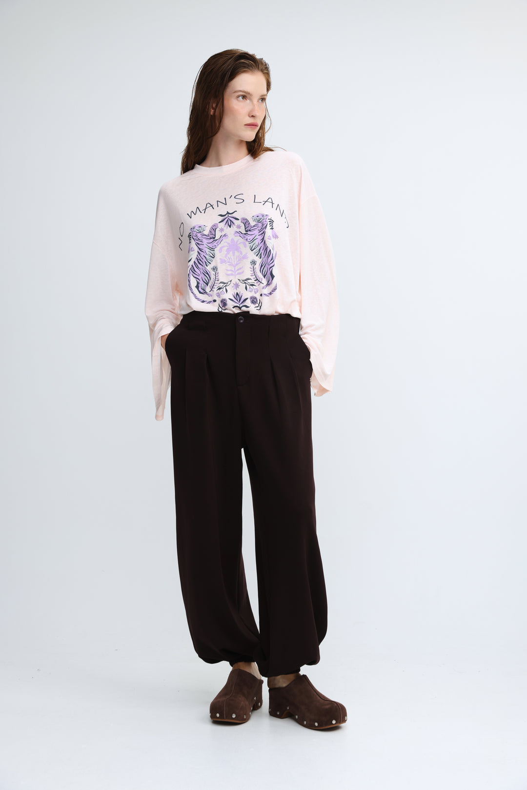 Everything brown bottoms soft pink long-sleeved sweatshirt with purple and white wing and floral graphic on the chest front view