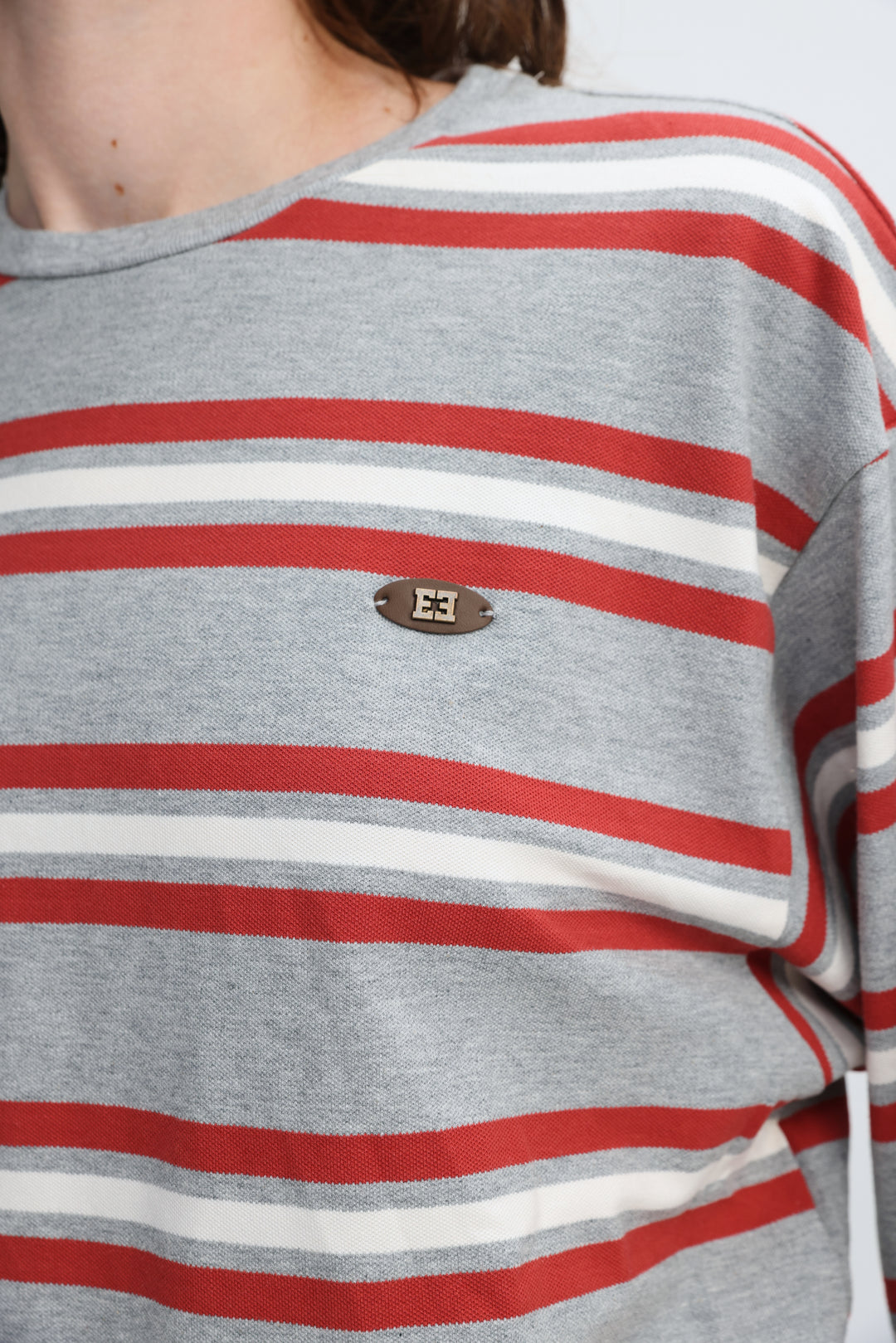 Federer grey striped long-sleeve top with red stripes and a small brown oval logo patch on the chest front view