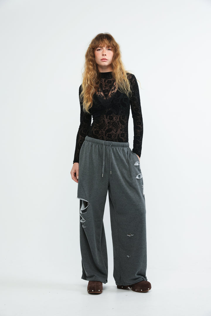 Dark gray wide-leg sweatpants with distressed ripped details and drawstring waistband shown from the front