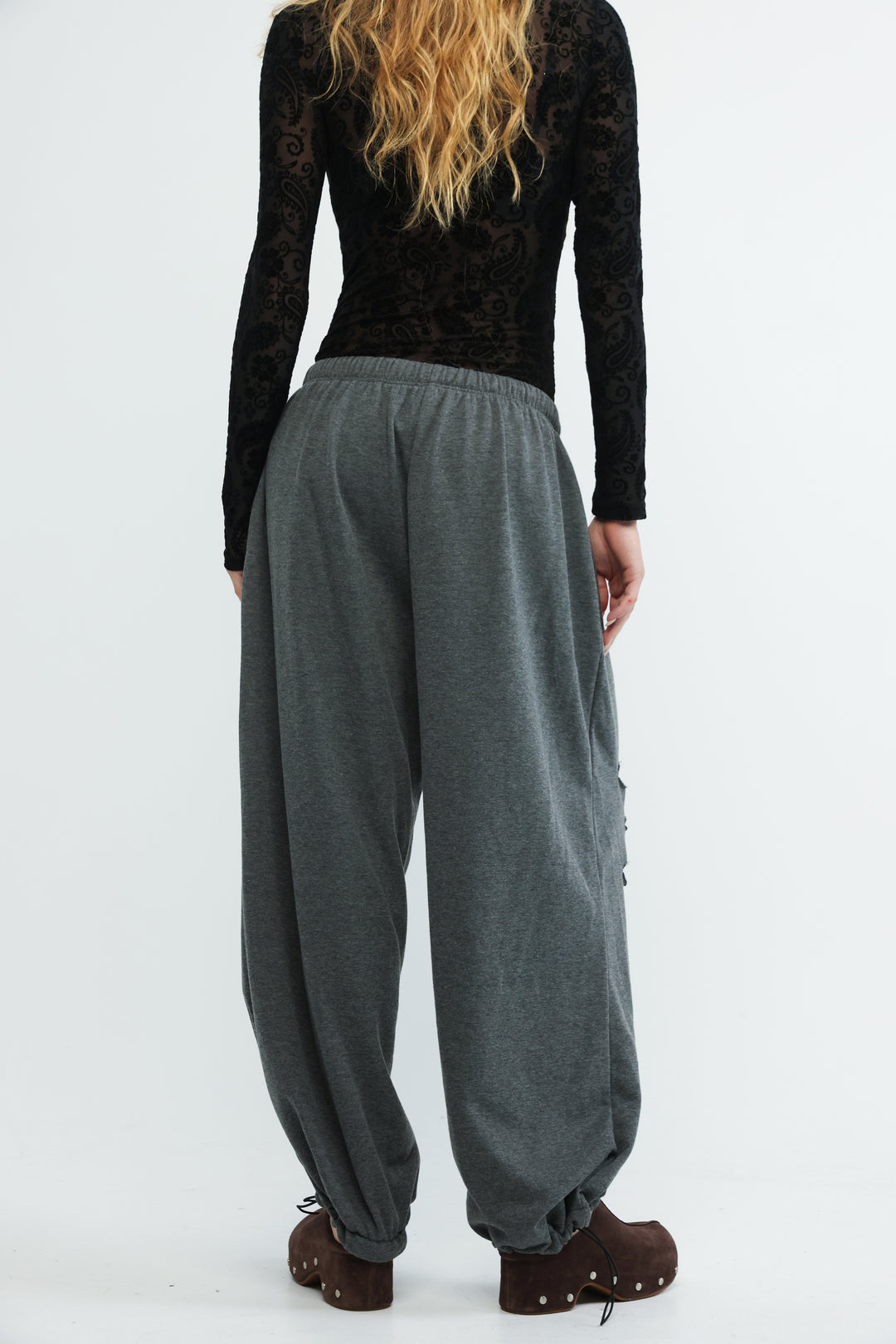 Gray loose-fitting harem joggers with elastic waistband and gathered cuffs shown from the front