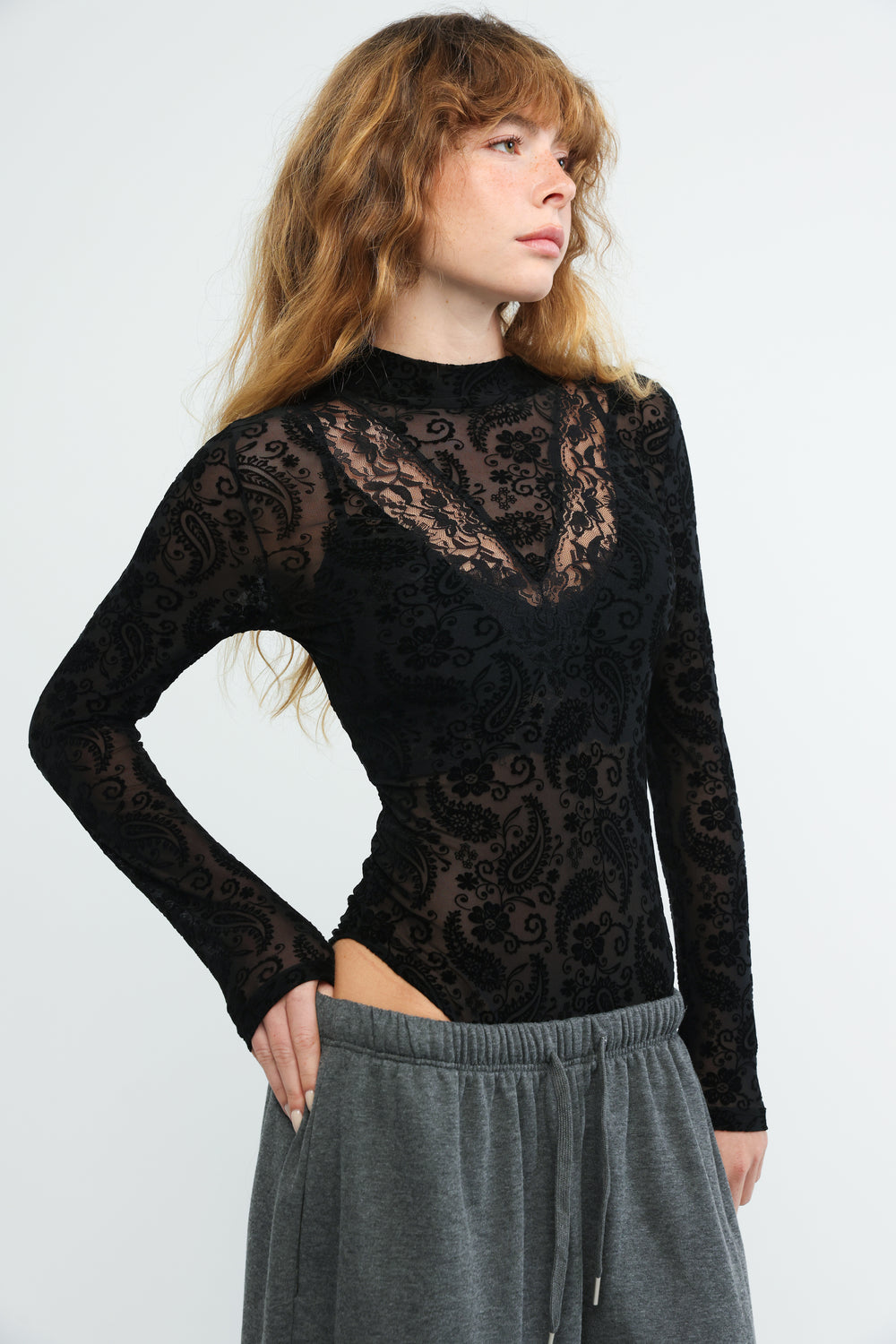 Black lace Claim black bodysuit with intricate paisley patterns and a high neckline shown from the front