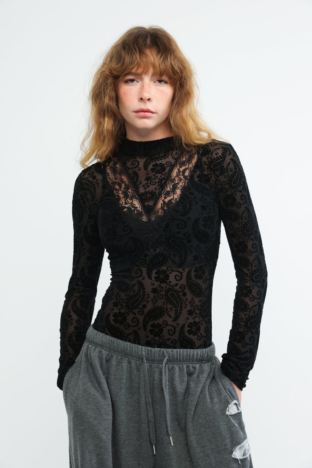 Black lace Claim bodysuit with intricate paisley pattern and sheer long sleeves shown from the front