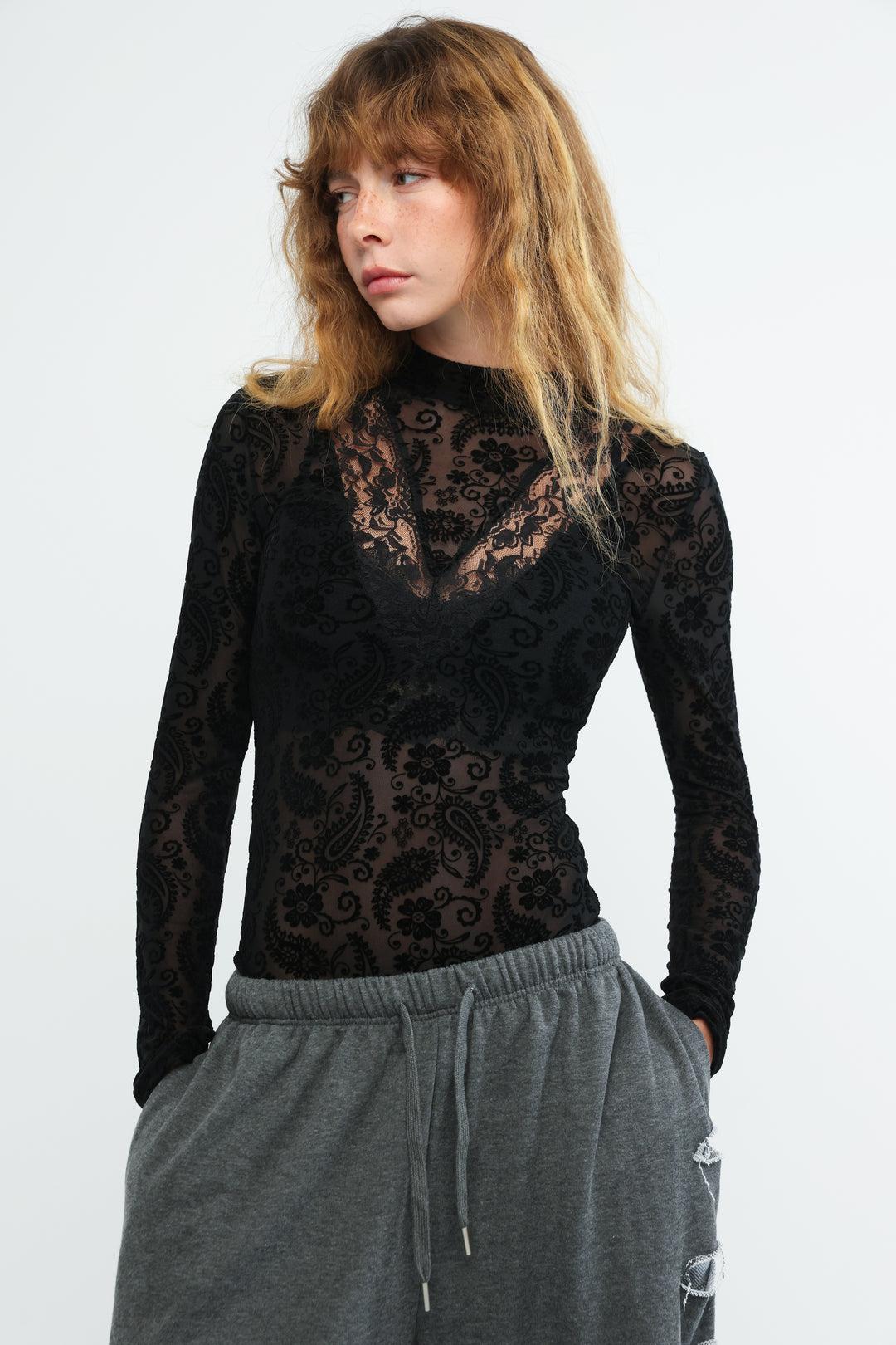 Claim black bodysuit featuring a long-sleeved lace top with intricate floral and paisley patterns front view