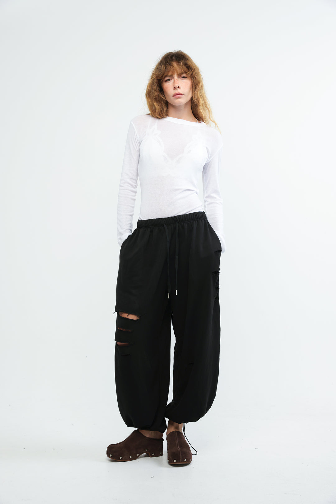 Black wide-leg joggers with distressed ripped details and drawstring waistband shown from the front