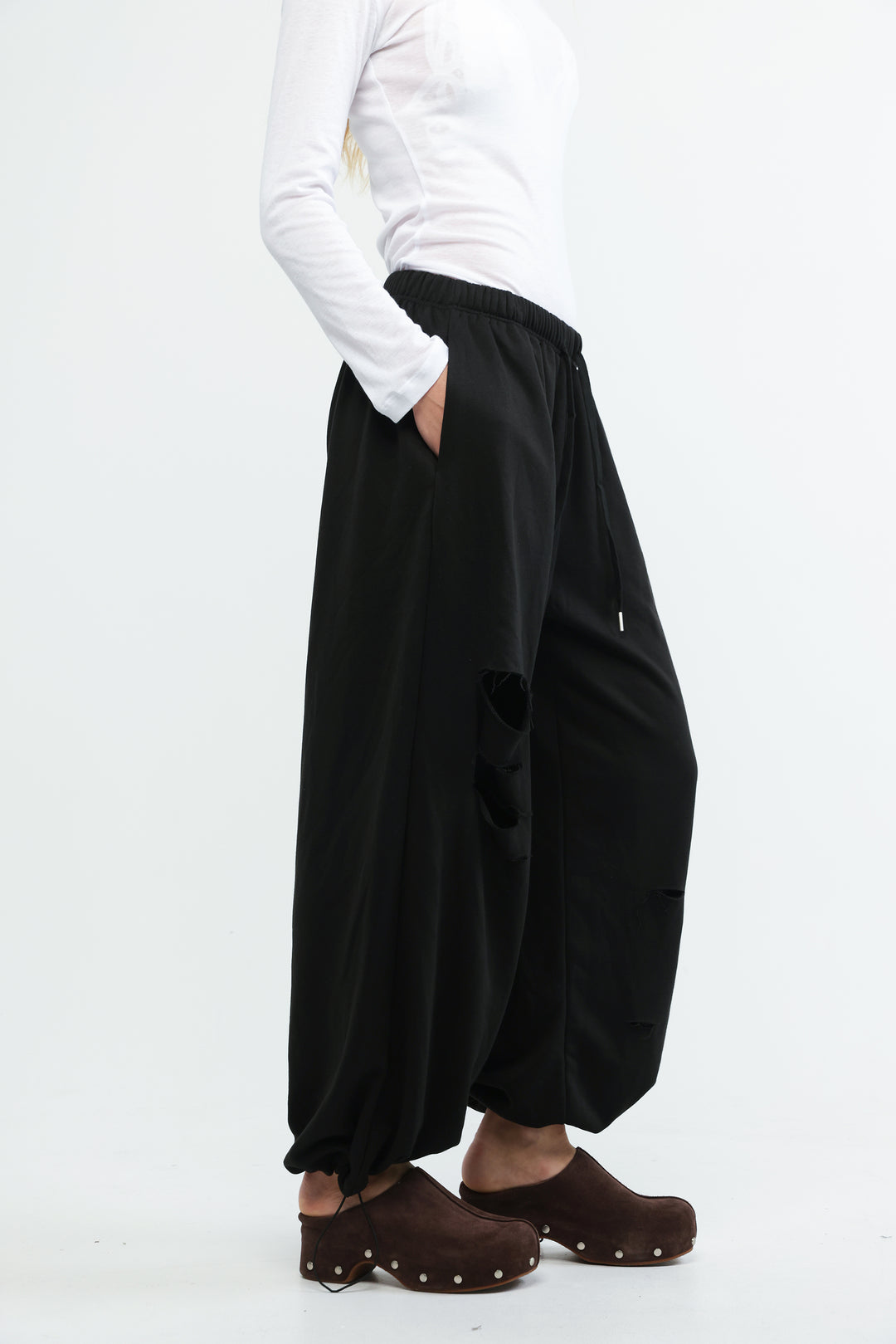 Black wide-leg joggers with relaxed flowing silhouette and subtle distressing details shown from the front