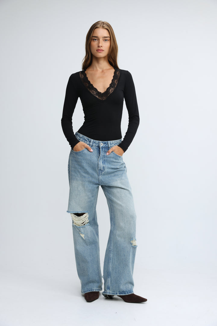 Black long-sleeved shirt with delicate lace trim at the neckline shown from the front